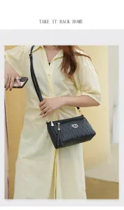 Classic black soft leather crossbody bag for women with stylish tassel and metal heart decor.