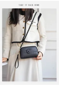 Detailed view of women fashion black crocodile pattern mini crossbody phone bag with strap.