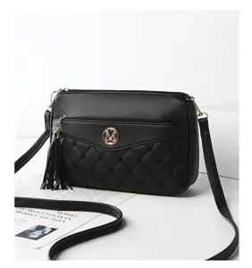 Black crossbody shoulder bag detail featuring elegant tassel and quilted front pocket design.