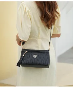 Stylish women crossbody bag black leather shoulder bag with chic heart charm and tassel design.