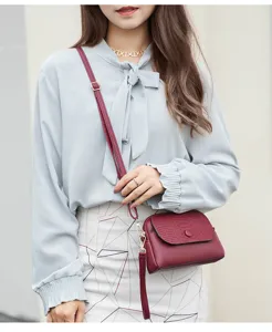 Vue détaillée d'un sac bandoulière bordeaux pour femme avec motif croco et détails dorés.