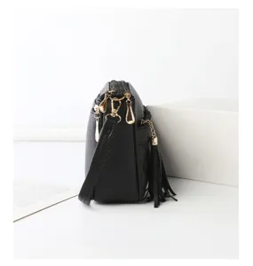 Black leather shoulder bag side profile close-up, multi-pocket design with chic tassel.