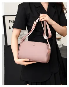 Pink leather crossbody shoulder bag for women featuring a stylish patterned strap, detail view.