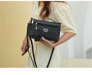 Black quilted soft leather crossbody bag featuring stylish tassel pendant and heart buckle detail.