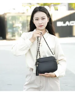 Chic black leather crossbody bag for women with chain strap and stylish tassel detail.