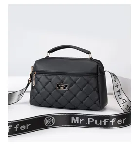 Black quilted crossbody bag with top handle and letter patterned wide shoulder strap.