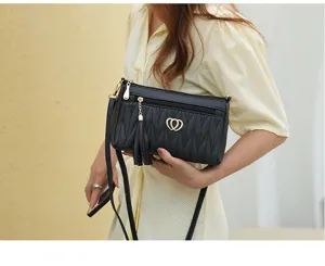 Women black crossbody shoulder bag detail view, showing multi-zipper design and tassel charm.