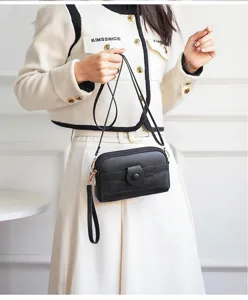 Black mini crossbody phone bag with textured PU leather, wrist strap, and compact design.