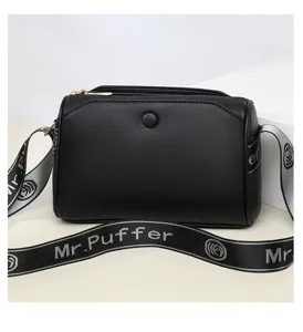 Black crossbody bag for women with multi-layer zippers and wide printed strap detail.