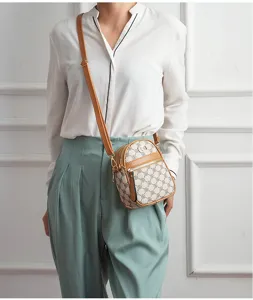 Detailed shot of a chic vertical crossbody phone bag featuring classic retro monogram.