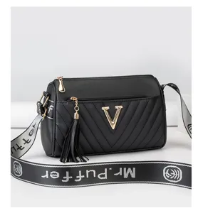 Crossbody shoulder cylinder bag, black leather with metallic V logo and wide strap.