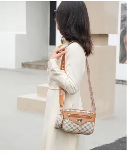 Chic brown monogram crossbody bag detail with wide strap and coin purse charm for women.