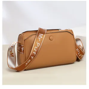 Close-up detail of the brown leather casual crossbody bag with wide strap and zippers.