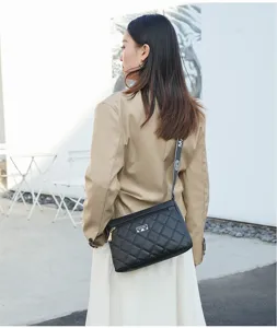 Vue détaillée du sac bandoulière noir matelassé montrant un cuir texturé et une sangle.