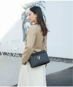 Stylish black quilted shoulder bag detail featuring elegant gold V logo and detailed stitching.