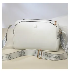 Detailed view of the white leather crossbody bag showcasing texture, zipper, and strap.