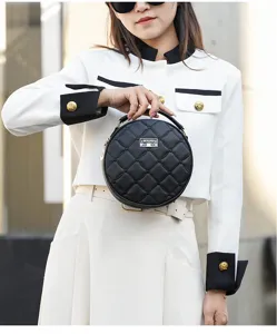 Detail view of the black quilted round handbag, featuring soft texture and chic metal logo accent.