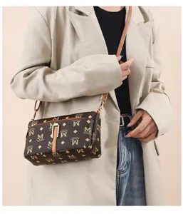 Sac bandoulière monogrammé marron pour femme avec bandoulière élégante et fermoir métallique.