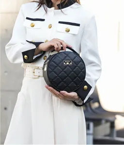 Chic quilted round handbag with top handle and gold tone hardware, stylish crossbody design.