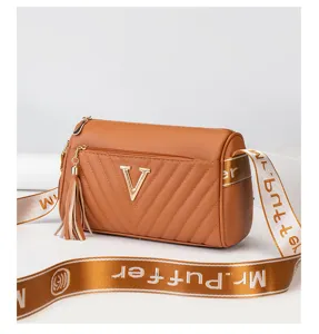 Brown cylindrical crossbody shoulder bag with metal V logo, quilted pattern and wide strap.