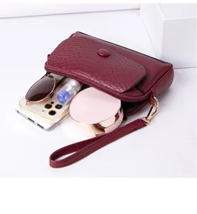 Vue détaillée d'une pochette rouge pour femme montrant le rangement intérieur pour téléphone.