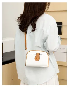 White leather crossbody bag detail, stylish single shoulder bag with brown strap.