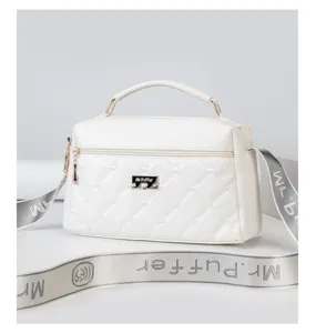White quilted crossbody shoulder bag with fabric strap, detailed metal logo plaque, ideal daily use.