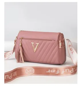 Pink cylindrical crossbody shoulder bag with quilted chevron pattern and wide logo strap.