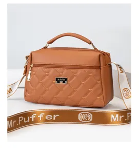 Brown quilted leather handbag close-up showing golden hardware detail and wide branded strap.