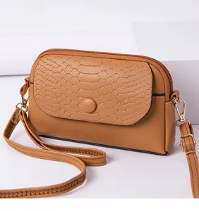 Élégant mini sac bandoulière marron avec rabat effet peau de serpent mode femme vue détail.