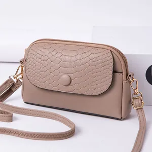 Vue rapprochée de détail de mini sac bandoulière, rabat effet serpent kaki et quincaillerie dorée.