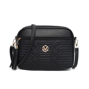 Sac bandoulière noir en cuir matelassé avec pompon et logo en métal pour femme chic.
