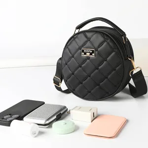 Black quilted round crossbody bag for women with chic heart pattern, top handle and strap.