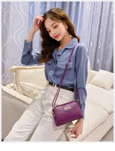 Detail shot of women's purple mini crossbody bag with chic bow accent and textured leather design.