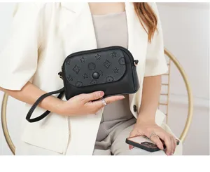 Detailed view of the black mini crossbody bag, featuring embossed star and floral patterns.