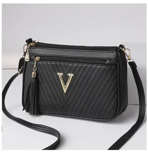 Stylish women black PU leather crossbody shoulder bag with metal V logo and tassel charm.