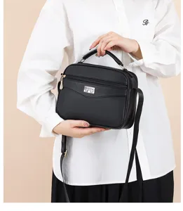 Black PU leather shoulder bag with top handle and front zipper pocket for women daily commuting.