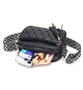 Black quilted crossbody bag with wide geometric strap, multi-layer zipper and spacious interior.