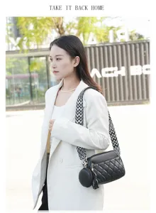 Details of stylish black quilted crossbody bag with wide patterned strap and round coin purse.