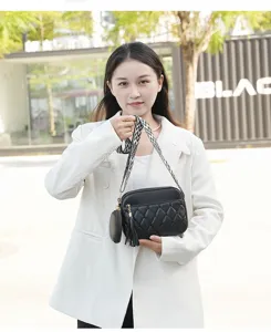 Detailed view of the stylish black quilted crossbody bag with wide strap and pouch.