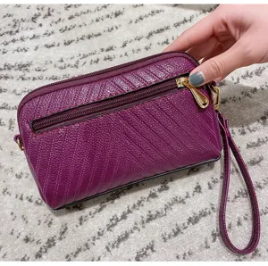 Detailed view of women's purple mini crossbody clutch bag with zipper and wrist strap.