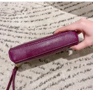 Detail view of purple textured leather mini handbag wristlet showcasing fine material.