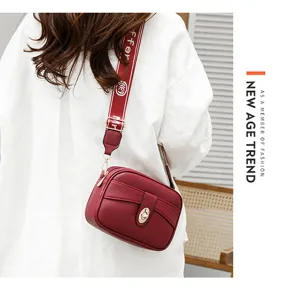 Vista detallada del elegante bolso cruzado de cuero PU rojo con correa ancha y cerradura metálica.