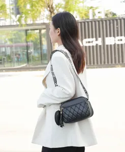 Stylish black quilted crossbody bag for women with wide patterned strap and small purse.