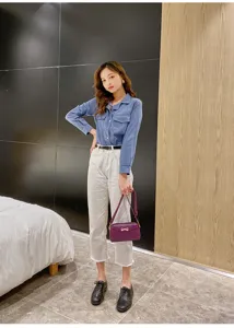 Detailed view of a mini purple fashion shoulder bag worn by an Asian model indoors.