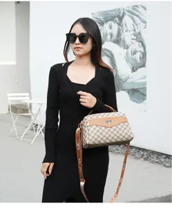 Elegante bolso de hombro cruzado vintage para mujer con ribete de cuero marrón.