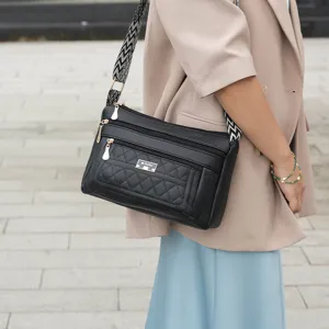 Classic black quilted crossbody bag for women with multi-zipper compartments and wide strap.