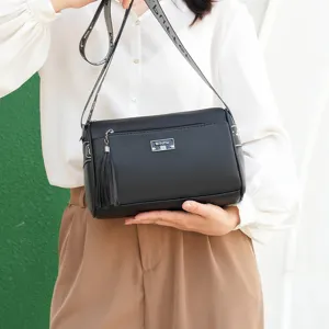 Black leather shoulder bag for women, casual commuting pillow bag with tassel charm.
