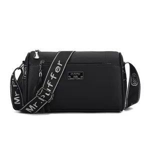 Black commuter shoulder bag for women, stylish pillow crossbody bag with wide logo strap.