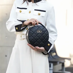 Stylish black round quilted crossbody bag with top handle and chic heart embroidery design.